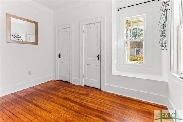 interior space with wood-type flooring and ornamental molding