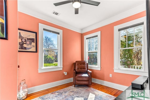 sitting room featuring hardwood / wood-style flooring, ceiling fan, and crown molding