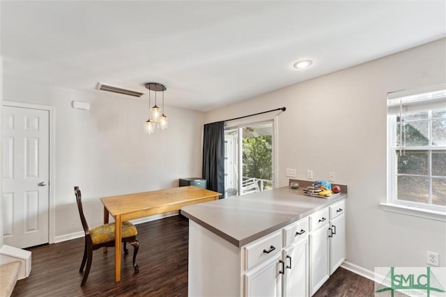 kitchen with dark hardwood / wood-style flooring, white cabinets, and decorative light fixtures