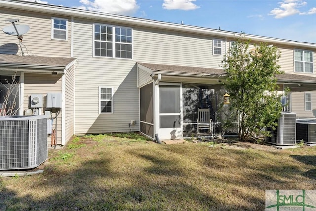 back of property featuring a yard, cooling unit, and a sunroom