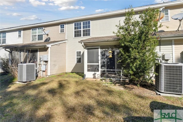 back of house with a sunroom, a yard, and central AC