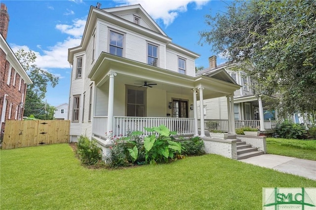 view of front of house featuring ceiling fan, a porch, and a front yard