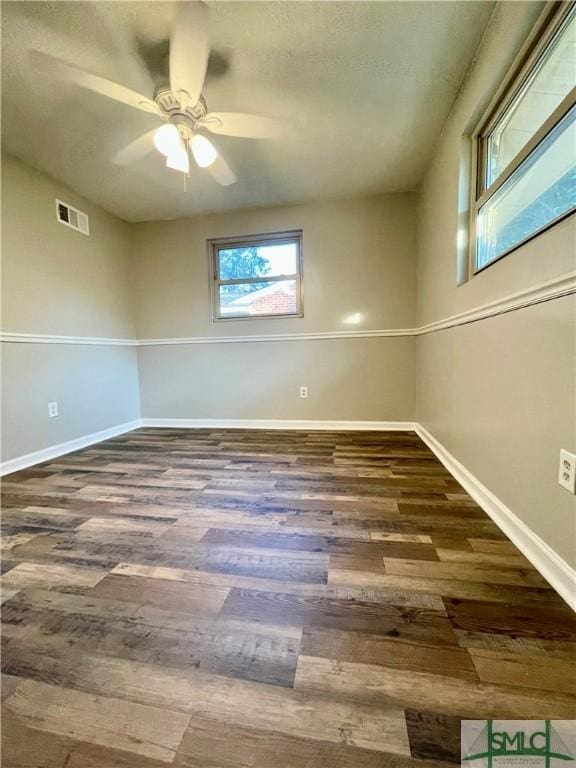 unfurnished room with ceiling fan and dark wood-type flooring