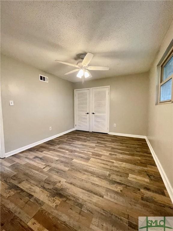 unfurnished bedroom with hardwood / wood-style floors, ceiling fan, and a textured ceiling