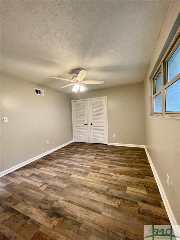 unfurnished bedroom with ceiling fan, hardwood / wood-style floors, and a textured ceiling