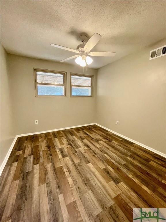 spare room featuring hardwood / wood-style floors, ceiling fan, and a textured ceiling