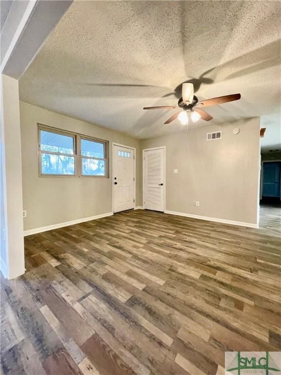 foyer entrance with ceiling fan, wood-type flooring, and a textured ceiling