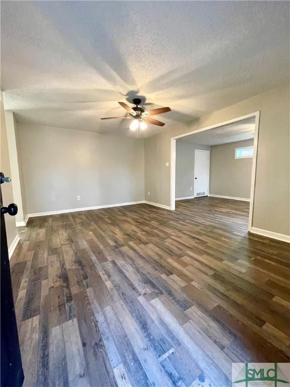 unfurnished room featuring a textured ceiling, ceiling fan, and dark wood-type flooring