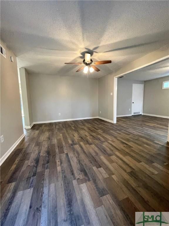 spare room with a textured ceiling, ceiling fan, and dark hardwood / wood-style floors