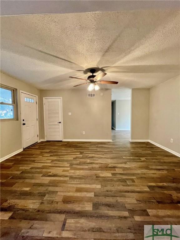 interior space with dark hardwood / wood-style floors, ceiling fan, and a textured ceiling