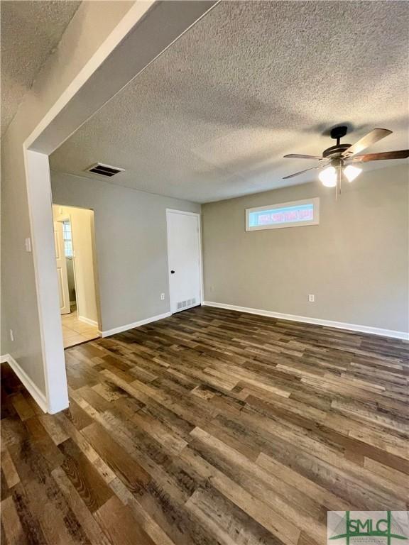 empty room featuring hardwood / wood-style flooring, ceiling fan, and a textured ceiling