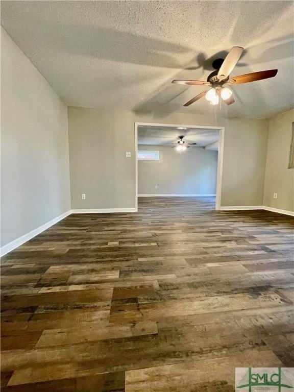 empty room featuring ceiling fan, dark hardwood / wood-style flooring, and a textured ceiling