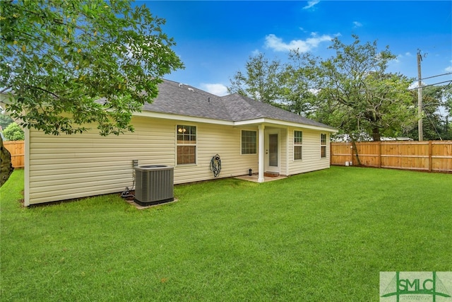 back of house featuring a yard and central air condition unit