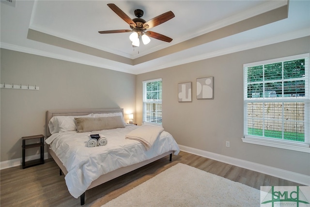 bedroom with a raised ceiling, ceiling fan, hardwood / wood-style floors, and crown molding