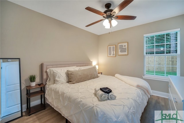 bedroom with ceiling fan and dark wood-type flooring