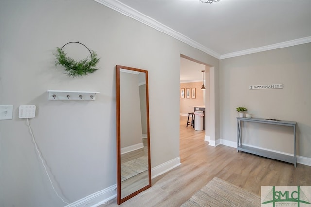 corridor featuring ornamental molding and light hardwood / wood-style flooring