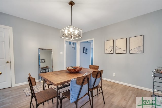 dining room featuring light wood-type flooring and a notable chandelier