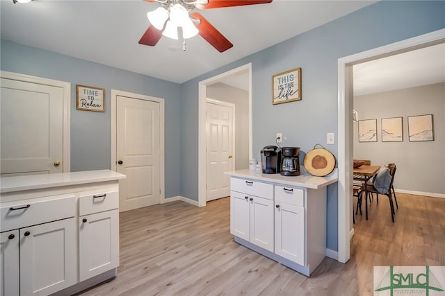 kitchen featuring ceiling fan, light wood-type flooring, and white cabinetry