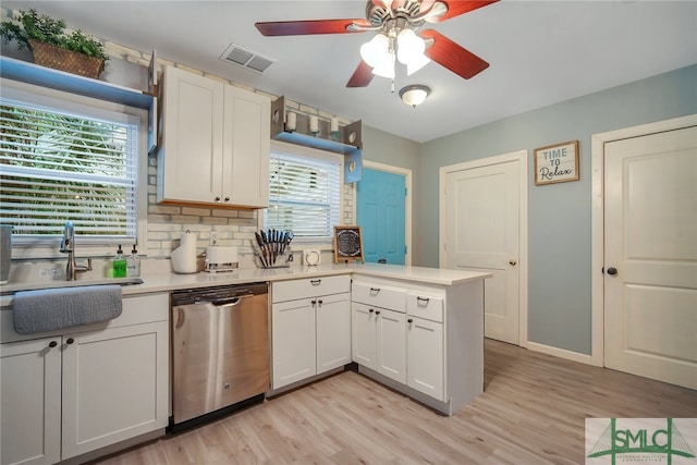 kitchen with dishwasher, white cabinets, light wood-type flooring, tasteful backsplash, and kitchen peninsula