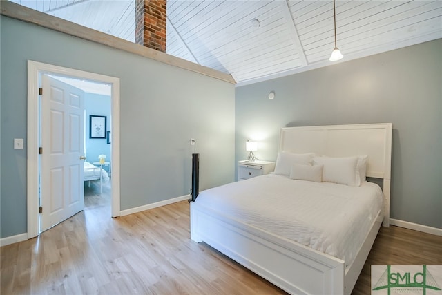 bedroom with light wood-type flooring, high vaulted ceiling, and wooden ceiling