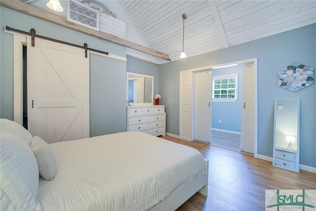 bedroom featuring a barn door, wood-type flooring, lofted ceiling, and wood ceiling