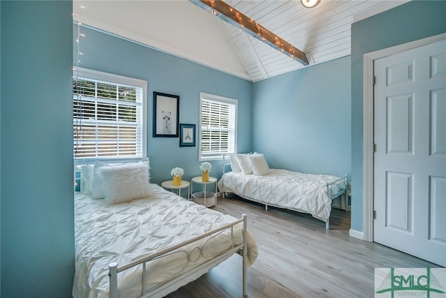 bedroom featuring vaulted ceiling with beams, light hardwood / wood-style flooring, and wood ceiling