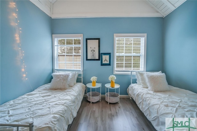 bedroom with hardwood / wood-style floors, vaulted ceiling, and ornamental molding