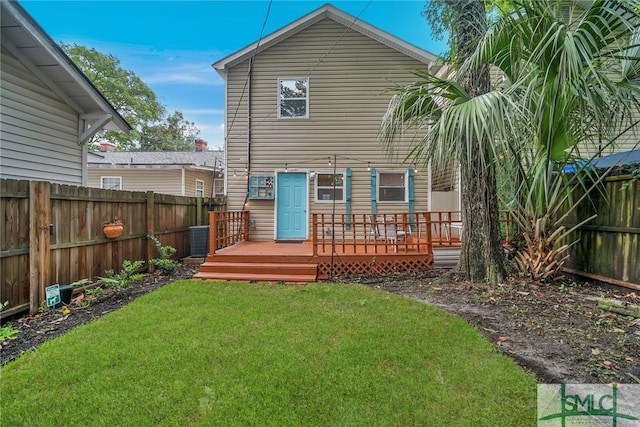 rear view of property featuring a lawn, cooling unit, and a wooden deck