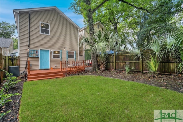 back of house featuring a lawn, cooling unit, and a wooden deck