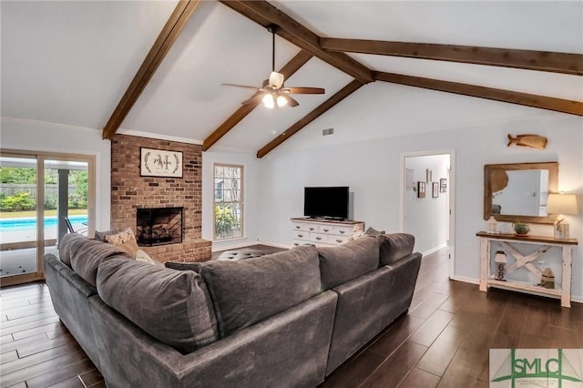 living room featuring a wealth of natural light, lofted ceiling with beams, a brick fireplace, and ceiling fan