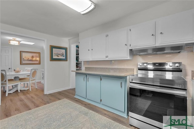 kitchen with blue cabinetry, light hardwood / wood-style flooring, stainless steel range with electric cooktop, ventilation hood, and white cabinets