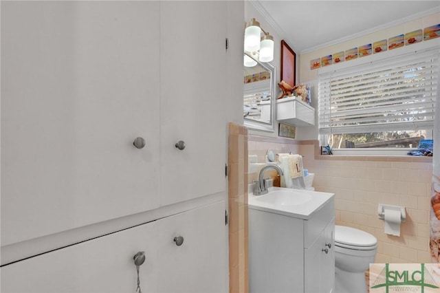 bathroom with vanity, toilet, crown molding, and tile walls