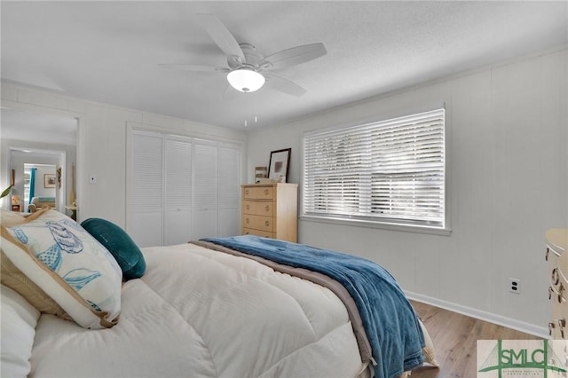 bedroom featuring light hardwood / wood-style flooring, a closet, and ceiling fan