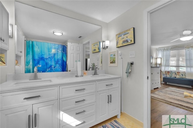 bathroom with ceiling fan, vanity, and wood-type flooring