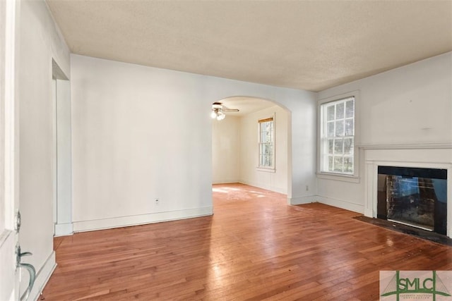 unfurnished living room featuring hardwood / wood-style flooring and ceiling fan