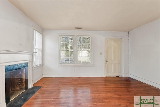 unfurnished living room featuring hardwood / wood-style floors and a wealth of natural light