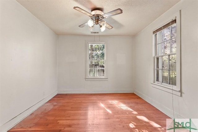 unfurnished room with light wood-type flooring, a textured ceiling, and ceiling fan