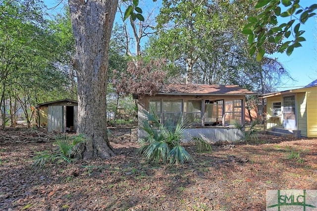 exterior space with a sunroom and a shed