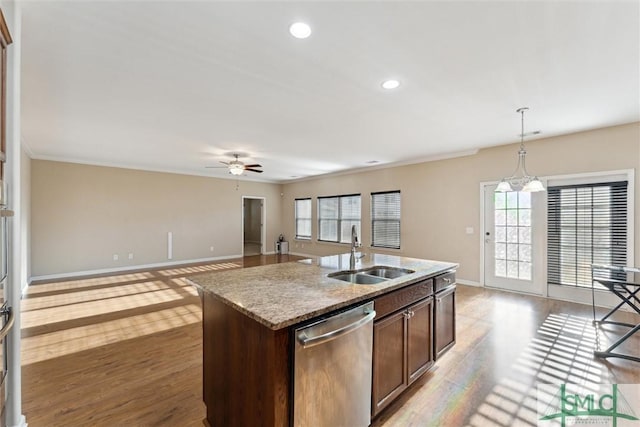 kitchen with dishwasher, sink, light hardwood / wood-style flooring, decorative light fixtures, and a kitchen island with sink