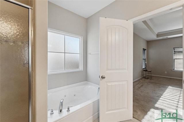 bathroom with ornamental molding, a raised ceiling, and independent shower and bath