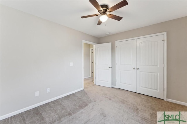 unfurnished bedroom with ceiling fan, light colored carpet, and a closet