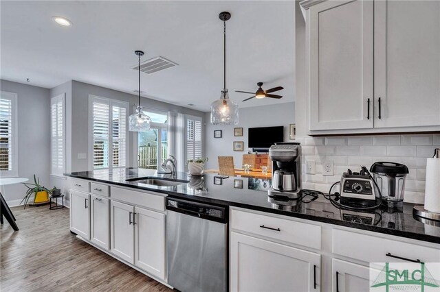 kitchen with dishwasher, sink, hanging light fixtures, decorative backsplash, and white cabinets