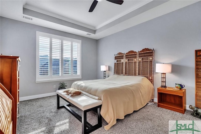 carpeted bedroom with a raised ceiling, ceiling fan, and crown molding