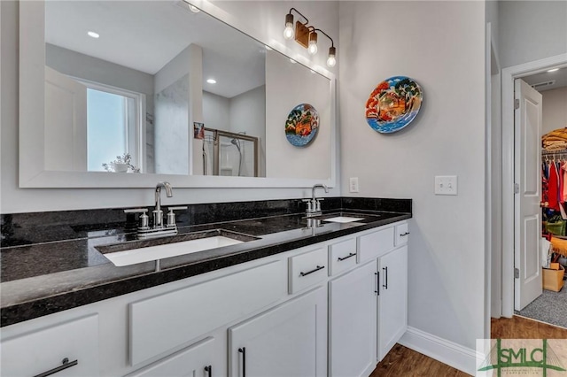 bathroom featuring hardwood / wood-style floors, vanity, and walk in shower