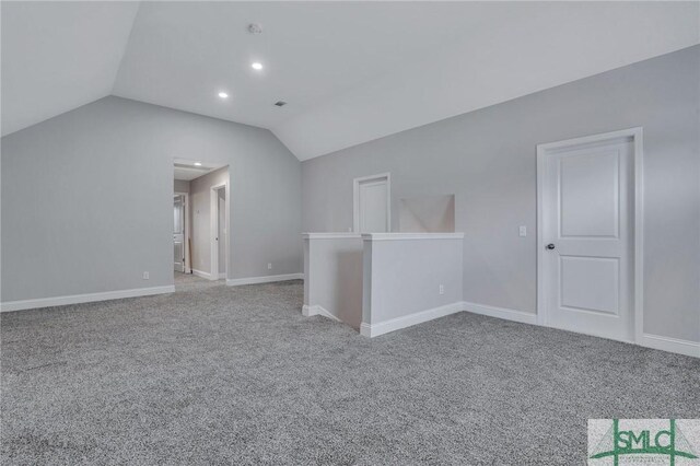 empty room with light carpet and lofted ceiling