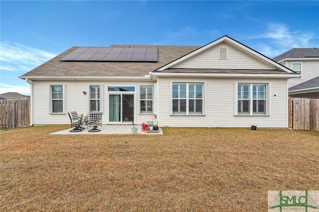 back of house featuring solar panels, a yard, and a patio