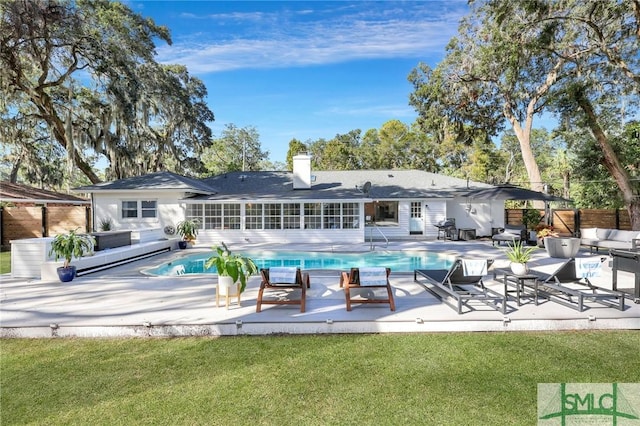 back of property with a yard, a patio, and an outdoor living space