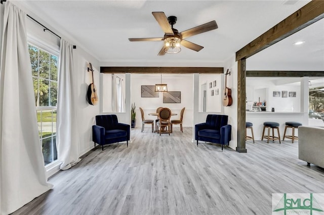 living area with ceiling fan, beam ceiling, and light hardwood / wood-style flooring