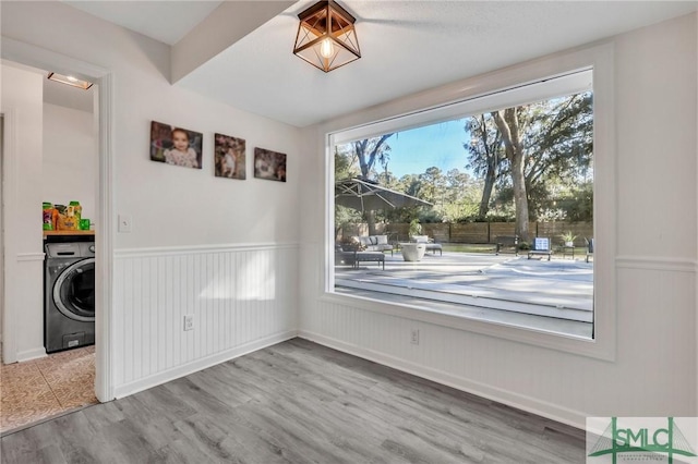 unfurnished dining area featuring washer / dryer and hardwood / wood-style floors