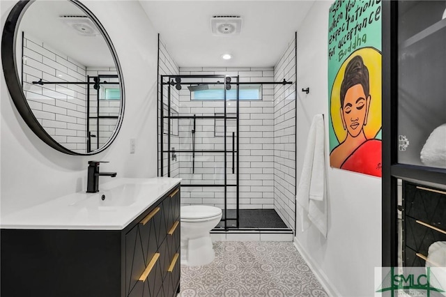 bathroom with toilet, vanity, tile patterned floors, and a shower with shower door